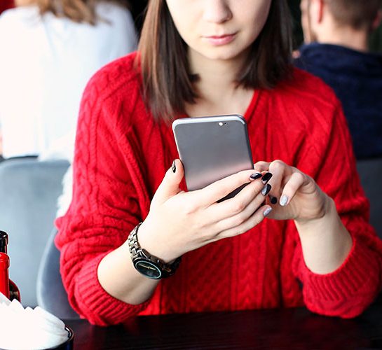 women in red sweater on phone